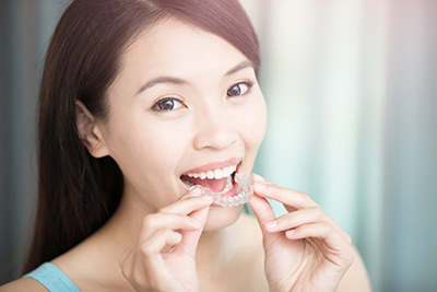 woman showing her Invisalign aligners