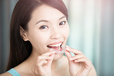 woman showing her Invisalign aligners she got from Cape Vista Dental