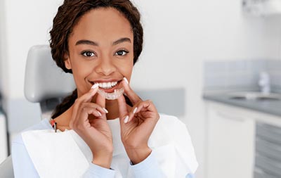 woman putting in her Invisalign clear aligners