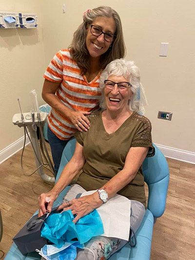 dental implant patient sitting in chair smiling