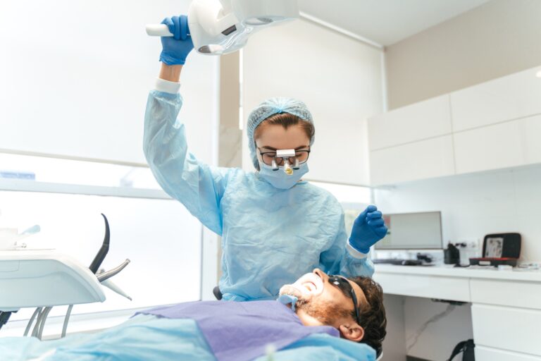 Female surgeon with microscope on head making dental operation