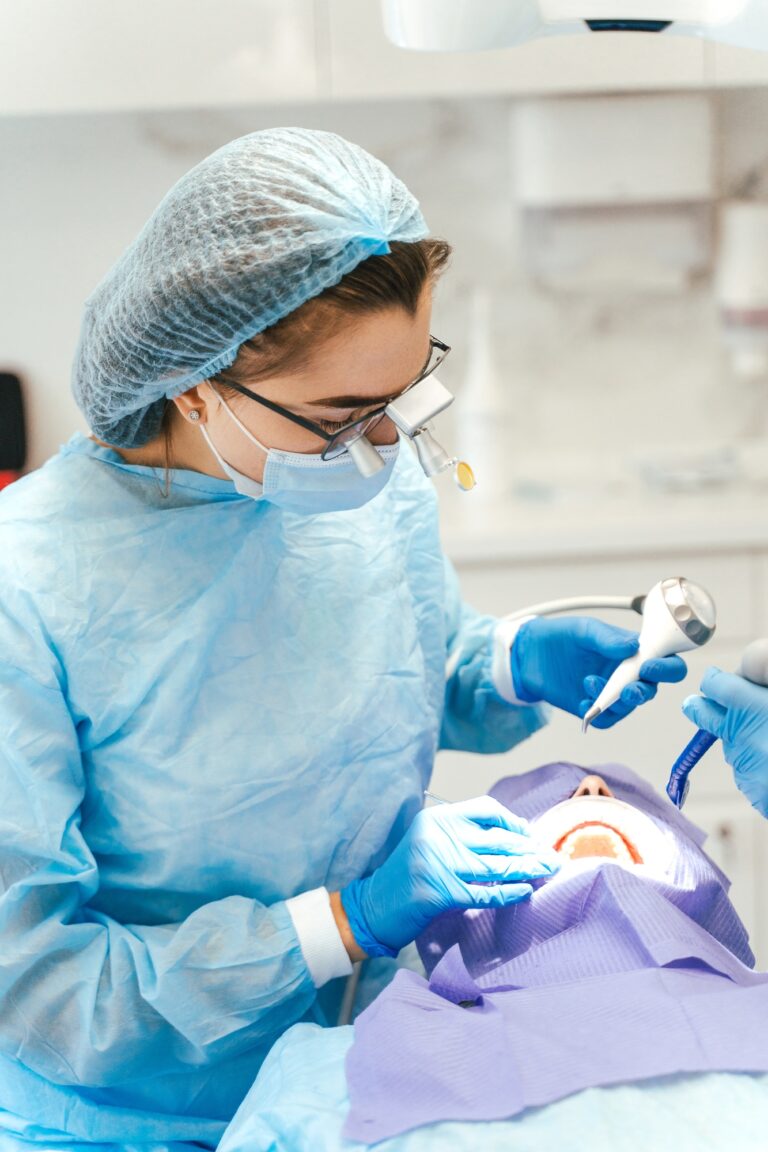 Female surgeon with microscope on head making dental operation